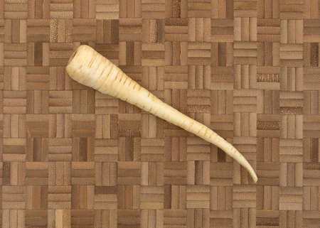 Top view of a single parsnip on a wood cutting board.の写真素材