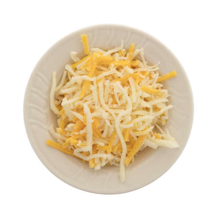 Top view of a blend of mozzarella and cheddar cheeses for pizza topping in a small bowl isolated on a white background.の写真素材