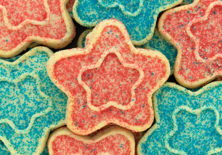 Close view of several star shaped sugar cookies with blue and red sprinkles.