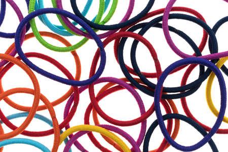 Top close view of a large group of elastic ponytail ties on a white background.