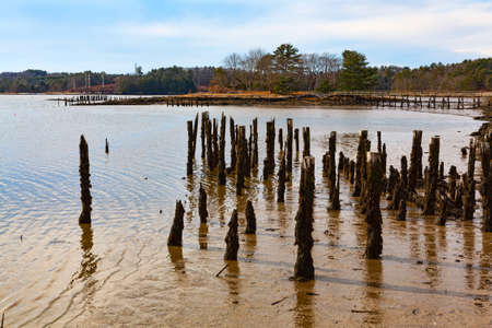 Wide view of the remains of a pier at low tide at Wiscasset Maine in the late fall.の写真素材