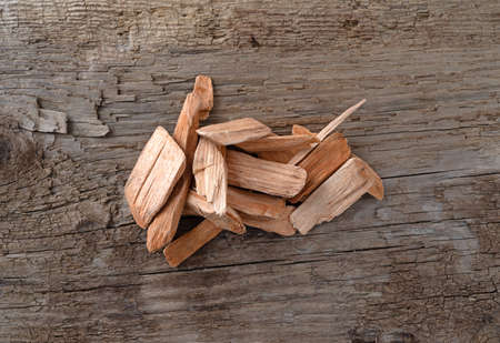 Small pile of alder wood smoking chips for barbecuing on a weathered background.