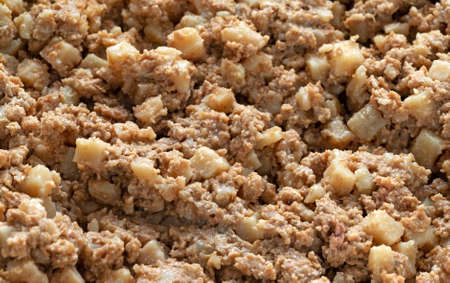 Close view of cold hash and sausage in a frying pan illuminated with natural lighting.