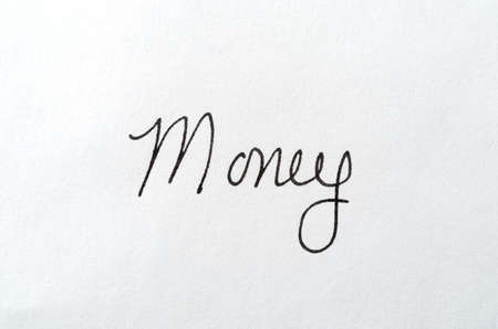 Top view of the word money written on a white piece of paper.