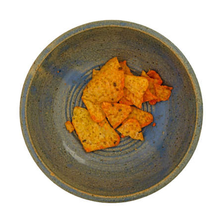 Top view of a bowl of broken cheese flavored tortilla chips isolated on a white background.の写真素材
