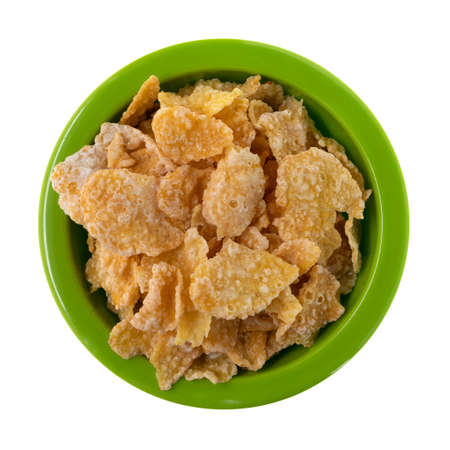Top view of generic frosted corn flakes in a green bowl isolated on a white background.
