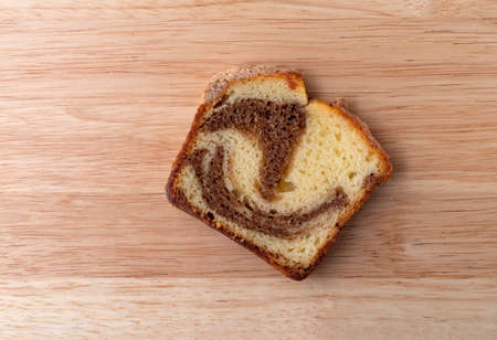 Top view of a slice of a freshly baked cinnamon marble pound cake on a wood tabletop.
