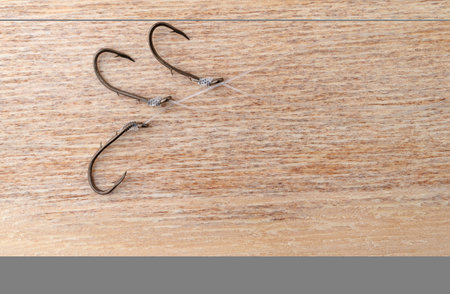 Bait hooks with snell leader attached on a wood background.の写真素材