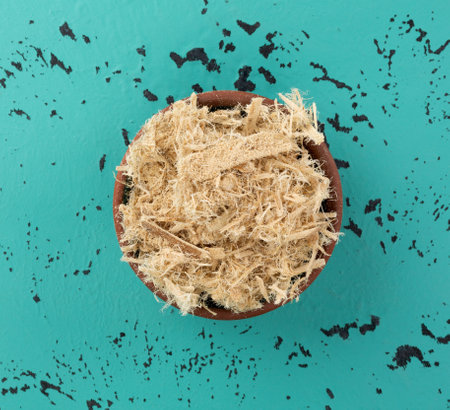 Overhead view of a small bowl filled with shredded slippery elm bark on a tabletop.の写真素材