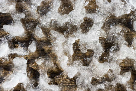 Close up of snow melting on a wooden structure in the spring revealing unique patterns and texture.の写真素材