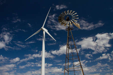 An old prairie windmill is set against a modern wind generator.のeditorial素材