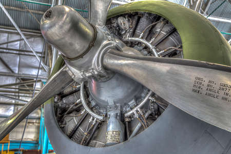 Old military prop airplane with 3 props and view of the engine and cowling