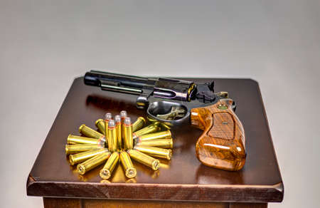Revolver laying on a table with ammo arrangedの写真素材