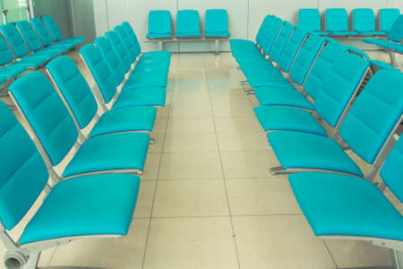 Row of blue seats in waiting airport roomの写真素材