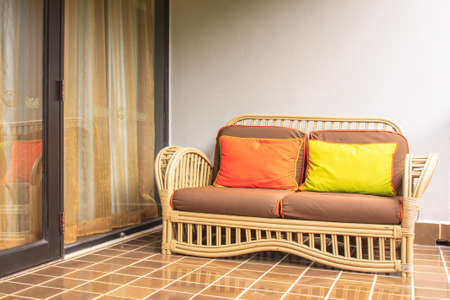 Rattan sofa and pillows on terrace of homeの写真素材