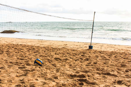 Volleyball net and ball on empty beach in twilightの写真素材