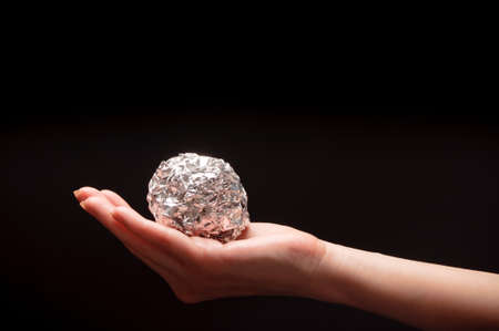 woman holding an aluminum foil on a black background