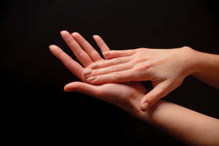 Female hands clapping on black, side-viewの写真素材