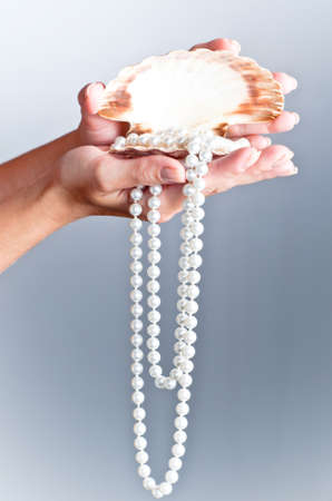shells and pearls on handの写真素材