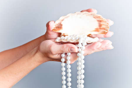 shells and pearls on handの写真素材