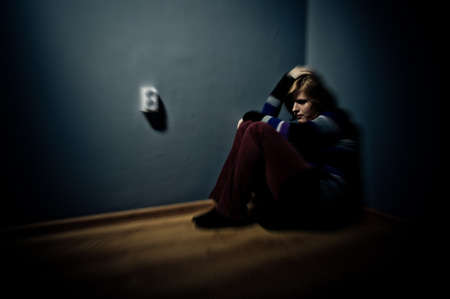 sad woman sitting alone in a empty roomの写真素材
