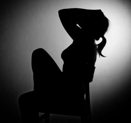 sad woman sitting alone in a empty room - black and whiteの写真素材