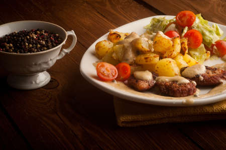 beef in pepper sauce with baked potatoes and salad  On a wooden backgroundの写真素材