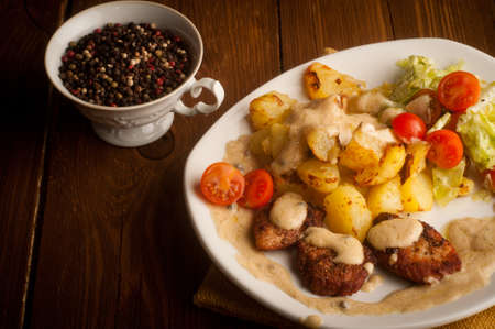 beef in pepper sauce with baked potatoes and salad  On a wooden backgroundの写真素材