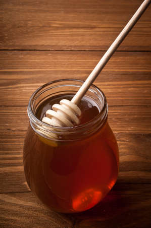 Honey drip in jar on the tableの写真素材