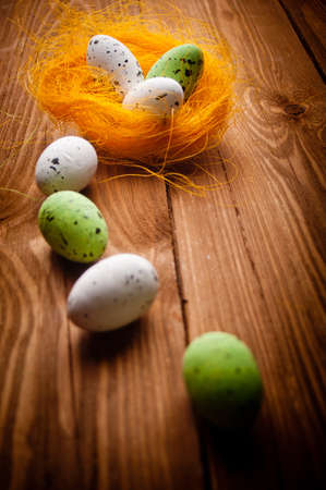 Easter eggs in nest on rustic wooden planksの写真素材