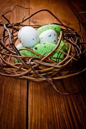 Easter eggs in nest on rustic wooden planksの写真素材