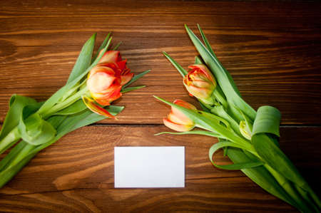 Tulips and blank card on old wooden boardsの写真素材