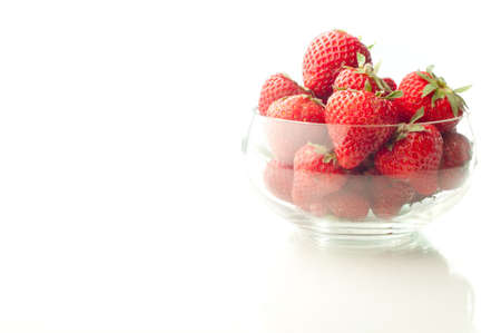 Strawberries in glass bowl on a white backgroundの写真素材