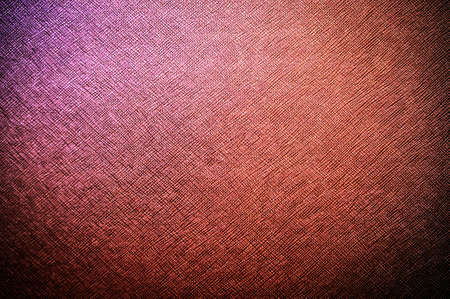 A vintage, textured canvas fabric background with a blue-brown to red gradientの写真素材