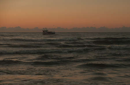 fishing boat while fishing at sunsetの写真素材