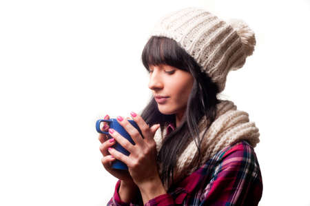a cold woman drinking a hot drinkの写真素材