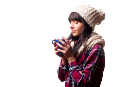 a cold woman drinking a hot drinkの写真素材