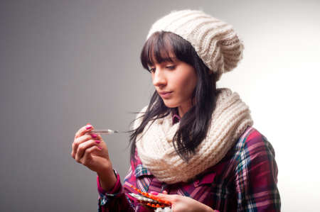 Woman with thermometer sick colds, flu, fever and migraineの写真素材