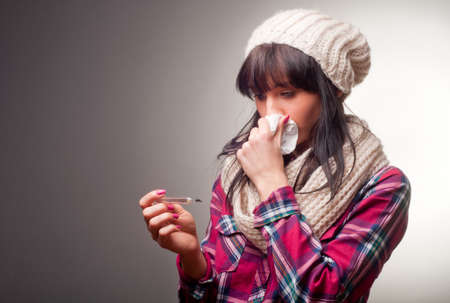 Woman with thermometer sick colds, flu, fever and migraineの写真素材