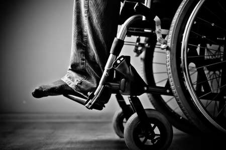 Close-up of male hand on wheel of wheelchairの写真素材