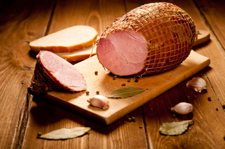 Whole ham with bread in the background, selective focusの写真素材