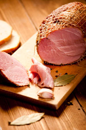 Whole ham with bread in the background, selective focusの写真素材