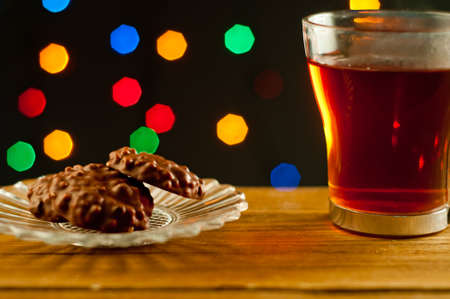 Tea served with biscuits. In the background blurry lightsの写真素材
