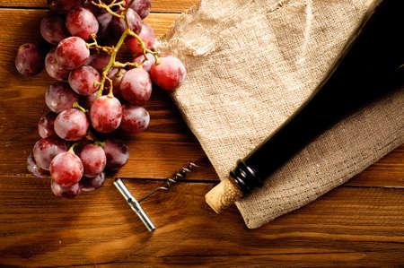 Red wine and grapes in vintage settingの写真素材