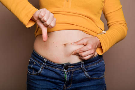 young girl shows her obesityの写真素材