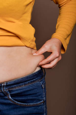 young girl shows her obesityの写真素材