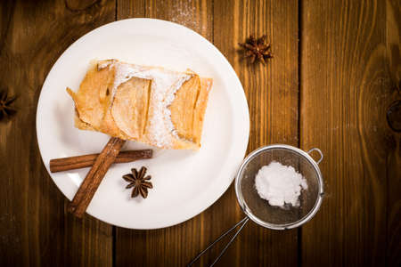 Apple pie on a wooden table. In the background, cinnamon, apple and aniseの写真素材