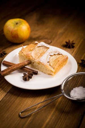 Apple pie on a wooden table. In the background, cinnamon, apple and aniseの写真素材