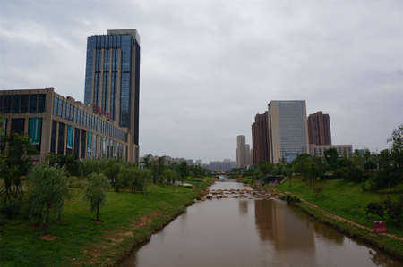 View of riverside park and buildings in a cityのeditorial素材