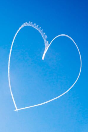 Romantic heart written in the blue sky by a small aircraftの写真素材